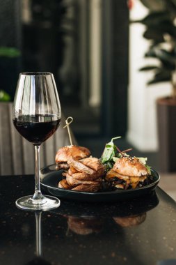 lezzetli hamburger ve kafede kırmızı şarap bardağı