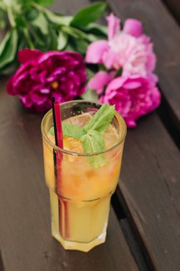 lezzetli tropikal kokteyl ile nane yaprakları, masaya pembe peony çiçek 