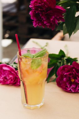 lezzetli tropikal kokteyl ile nane yaprakları, masaya pembe peony çiçek 