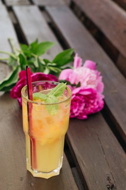 lezzetli tropikal kokteyl ile nane yaprakları, masaya pembe peony çiçek 