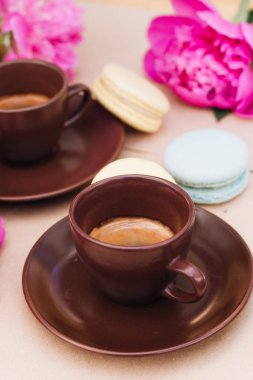 kahve ve pembe şakayık çiçekleri arka plan üzerinde kahverengi su bardağı