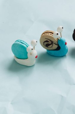 yaratıcı salyangoz süslemeleri ile mavi masada lezzetli macaroons