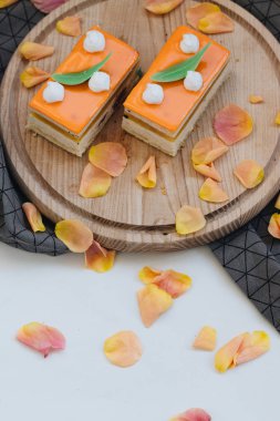 lezzetli pasta çiçek yaprakları ile süslenmiş ahşap tahta üzerinde iki adet 