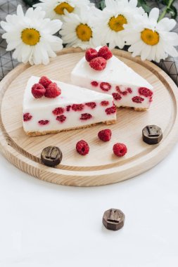 lezzetli kek ahududu ahşap tahta ve papatya çiçekler üzerinde ile iki adet