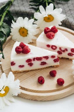 lezzetli kek ahududu ahşap tahta ve papatya çiçekler üzerinde ile iki adet