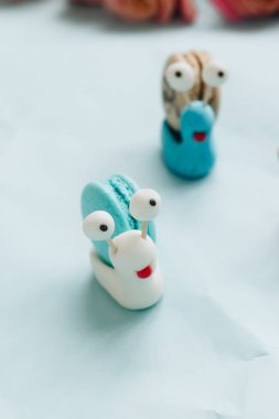 yaratıcı salyangoz süslemeleri ile mavi masada lezzetli macaroons