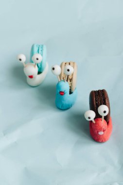 yaratıcı salyangoz süslemeleri ile mavi masada lezzetli macaroons