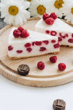 lezzetli kek ahududu ahşap tahta ve papatya çiçekler üzerinde ile iki adet