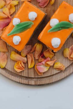 lezzetli pasta çiçek yaprakları ile süslenmiş ahşap tahta üzerinde iki adet 