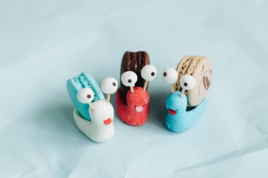 yaratıcı salyangoz süslemeleri ile mavi masada lezzetli macaroons