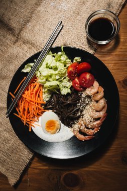 farklı malzemeler, yumurta, karides, domates, havuç, marul, susam ve deniz yosunu siyah plaka, Asya mutfağının lezzetli yemek 