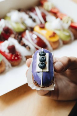 Erkek el ile sır, lezzetli pasta alarak renkli tatlı 