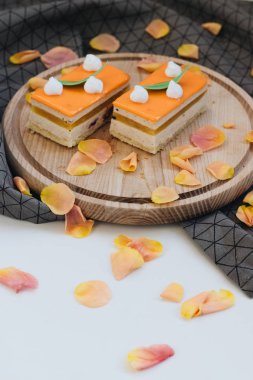 lezzetli pasta çiçek yaprakları ile süslenmiş ahşap tahta üzerinde iki adet 