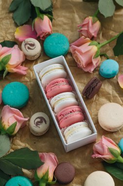 bileşimi lezzetli macaroons ve Kraft kağıt üzerinde pembe güller 