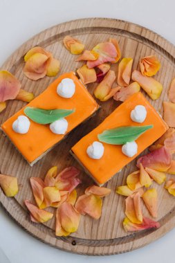 lezzetli pasta çiçek yaprakları ile süslenmiş ahşap tahta üzerinde iki adet 