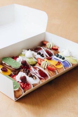 Renkli sır ile lezzetli eklerleri, kağıt kutusunda ayarlayın