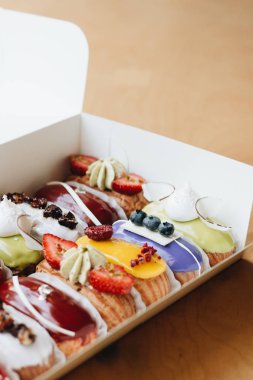 Renkli sır ile lezzetli eklerleri, kağıt kutusunda ayarlayın