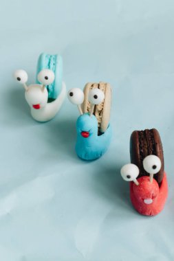 yaratıcı salyangoz süslemeleri ile mavi masada lezzetli macaroons