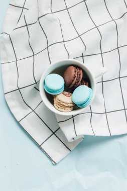 kompozisyon Kupası mavi masada, tatlı tatlı lezzetli macaroons 