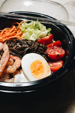 farklı malzemeler, yumurta, karides, domates, havuç, marul, susam ve deniz yosunu siyah plaka, Asya mutfağının lezzetli yemek 