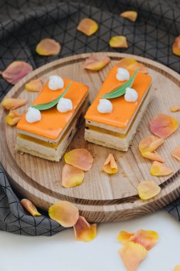 lezzetli pasta çiçek yaprakları ile süslenmiş ahşap tahta üzerinde iki adet 