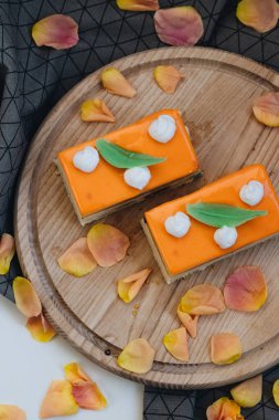 lezzetli pasta çiçek yaprakları ile süslenmiş ahşap tahta üzerinde iki adet 