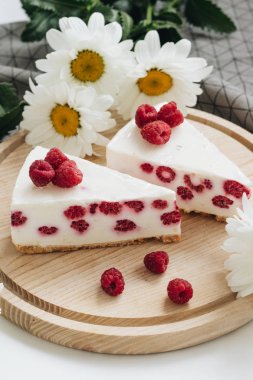 lezzetli kek ahududu ahşap tahta ve papatya çiçekler üzerinde ile iki adet