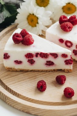 lezzetli kek ahududu ahşap tahta ve papatya çiçekler üzerinde ile iki adet