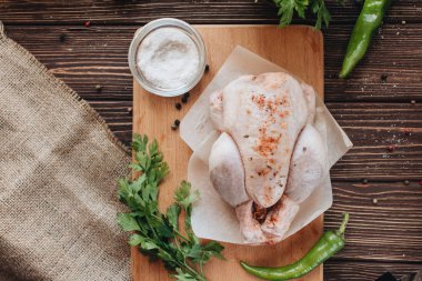 çiğ tavuk ve ahşap masa yemek pişirmek için hazır üzerinde taze otlar 
