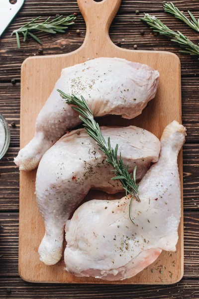 Ahşap tahta üzerinde rosemary ile çiğ tavuk budu 