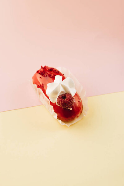 delicious eclair with red glaze and raspberry, sweet dessert 