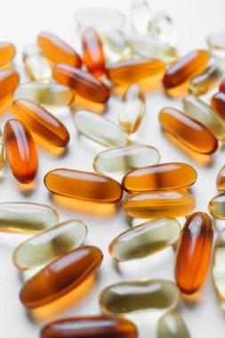 Beyaz arka plan üzerinde ilaç ile dağınık kapsül yığını 