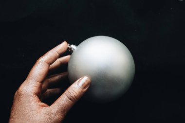 siyah arka planda gri Noel top tutan el 