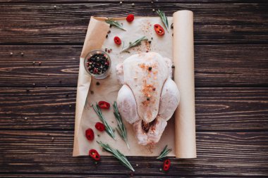 çiğ tavuk ve ahşap masa yemek pişirmek için hazır üzerinde taze otlar 