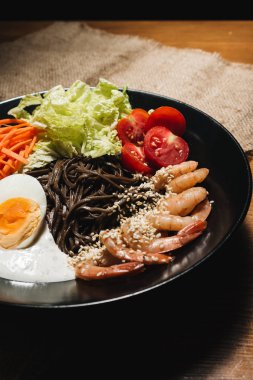 farklı malzemeler, yumurta, karides, domates, havuç, marul, susam ve deniz yosunu siyah plaka, Asya mutfağının lezzetli yemek 