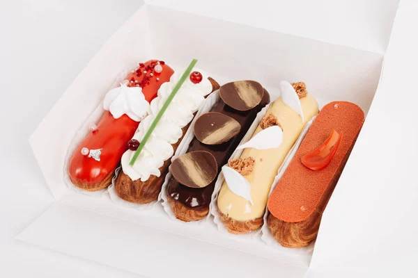 Conjunto Deliciosos Eclairs Com Esmalte Caixa Papel Entrega Sobremesa — Fotografia de Stock