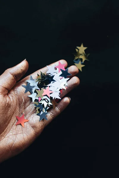 Mano Femenina Celebración Estrellas Confeti Fondo Negro — Foto de Stock