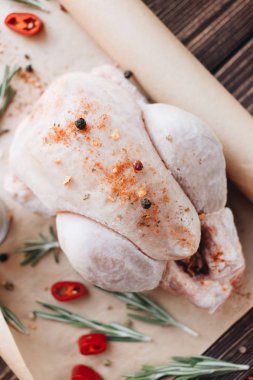 çiğ tavuk ve ahşap masa yemek pişirmek için hazır üzerinde taze otlar 