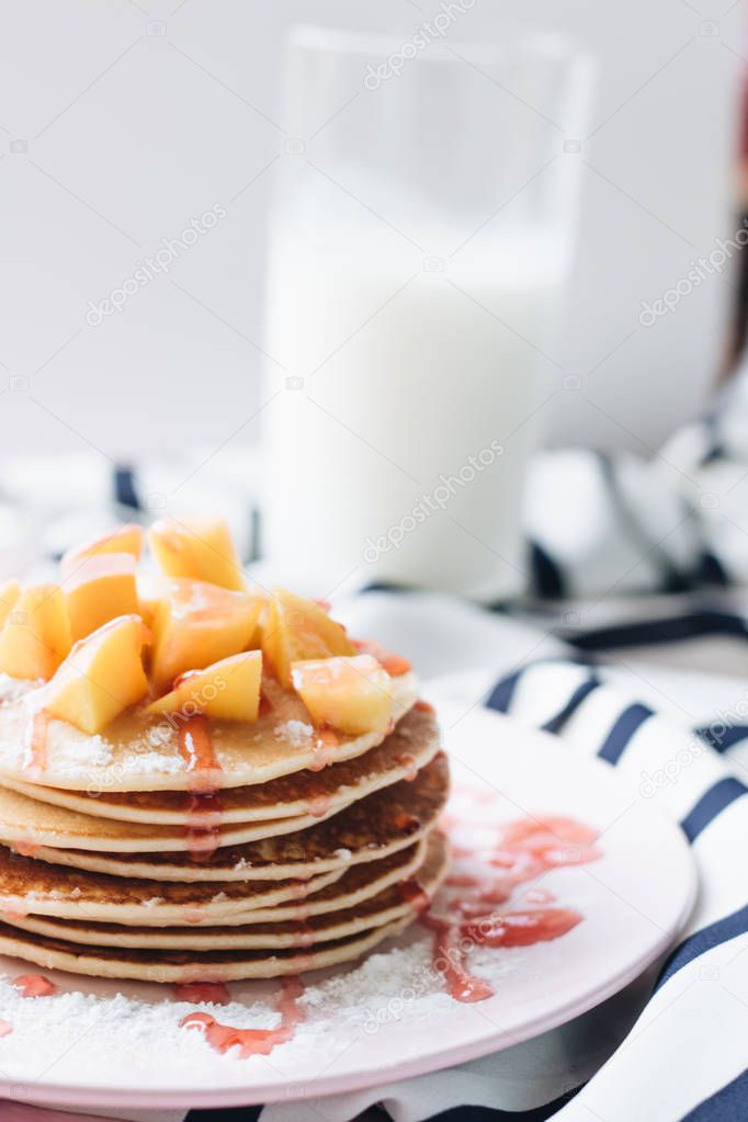 stack of delicious homemade pancakes with sauce and sliced apple 