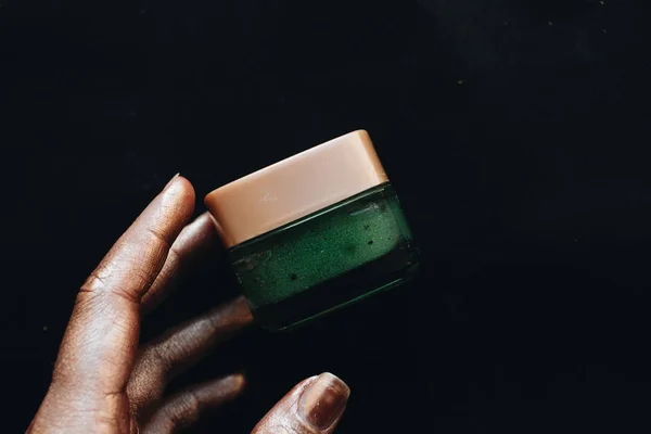 Contenedor Mano Femenina Con Crema Verde Sobre Fondo Negro — Foto de Stock