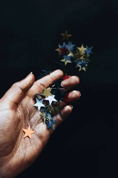Mano Femenina Celebración Estrellas Confeti Fondo Negro — Foto de Stock