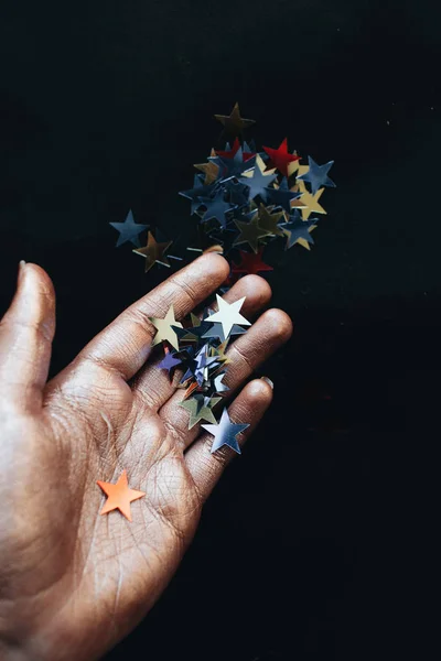 Mano Femenina Celebración Estrellas Confeti Fondo Negro — Foto de Stock