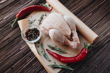 çiğ tavuk, biber ve taze otlar üzerinde ahşap masa yemek pişirmek için hazır 