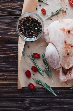 çiğ tavuk, biber ve taze otlar üzerinde ahşap masa yemek pişirmek için hazır 