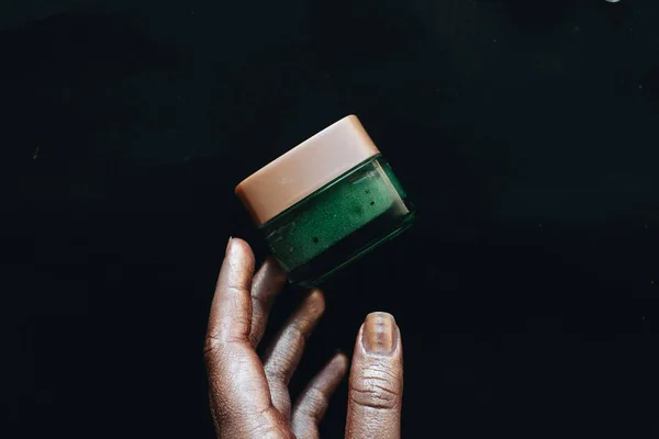 Contenedor Mano Femenina Con Crema Verde Sobre Fondo Negro — Foto de Stock