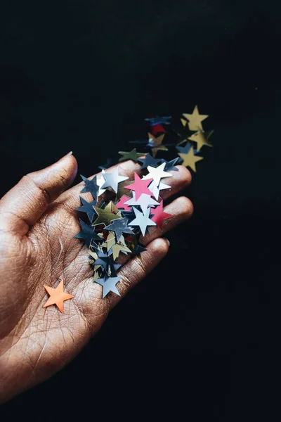 Mano Femenina Celebración Estrellas Confeti Fondo Negro — Foto de Stock