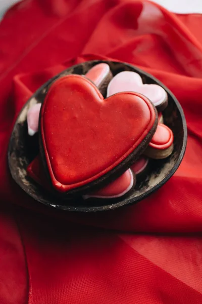 cookies in heart shape with red glaze on red textile