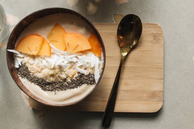 dilimlenmiş hurmon, fındık ve chia tohumu ile kase