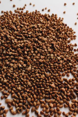 Beyaz arkaplanda dağınık ham karabuğday