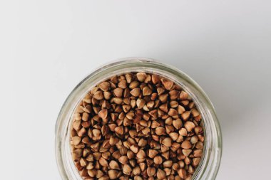 Beyaz arka plan üzerinde ham buğday ile jar